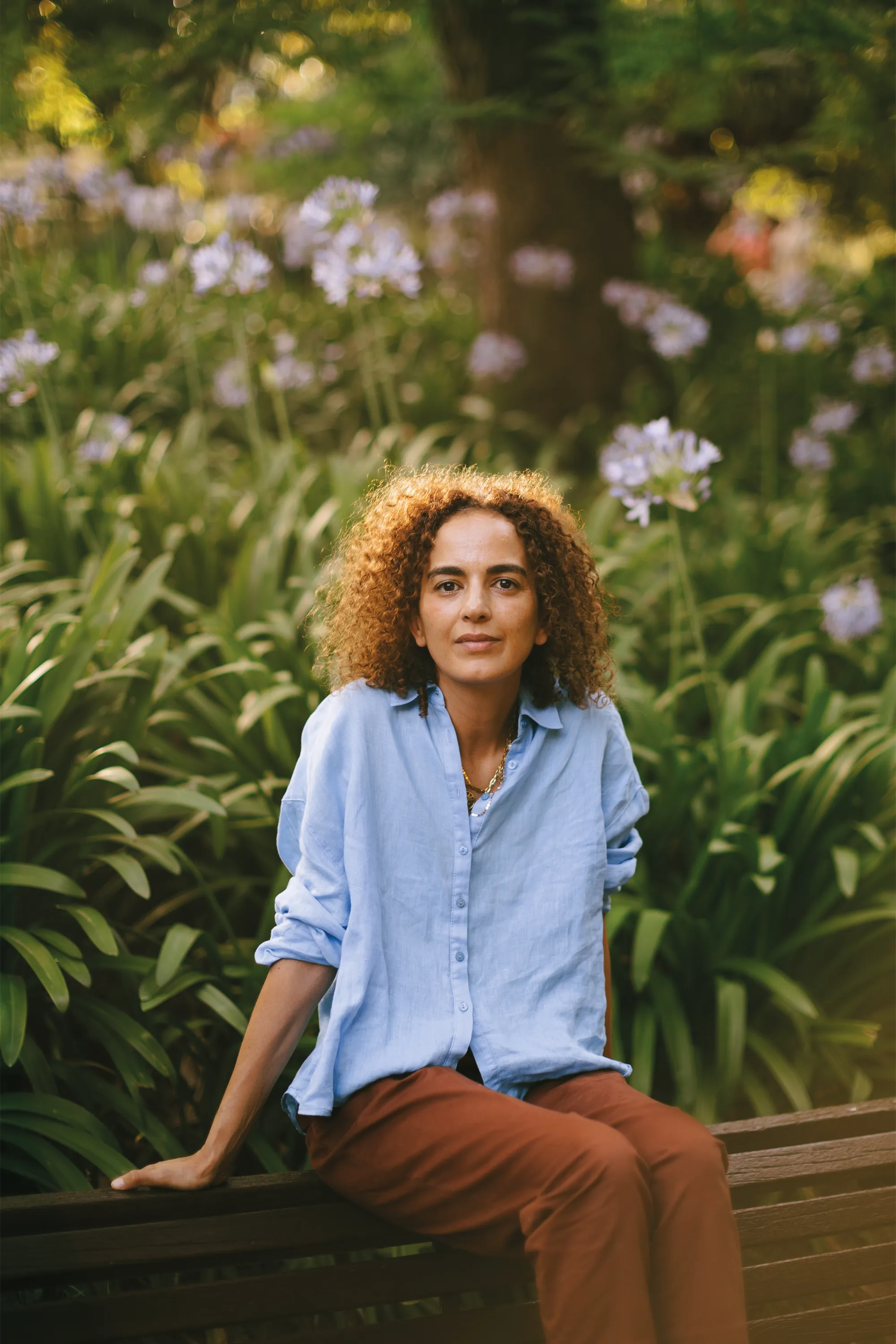Leïla Slimani, seated outdoors in a Lisbon park