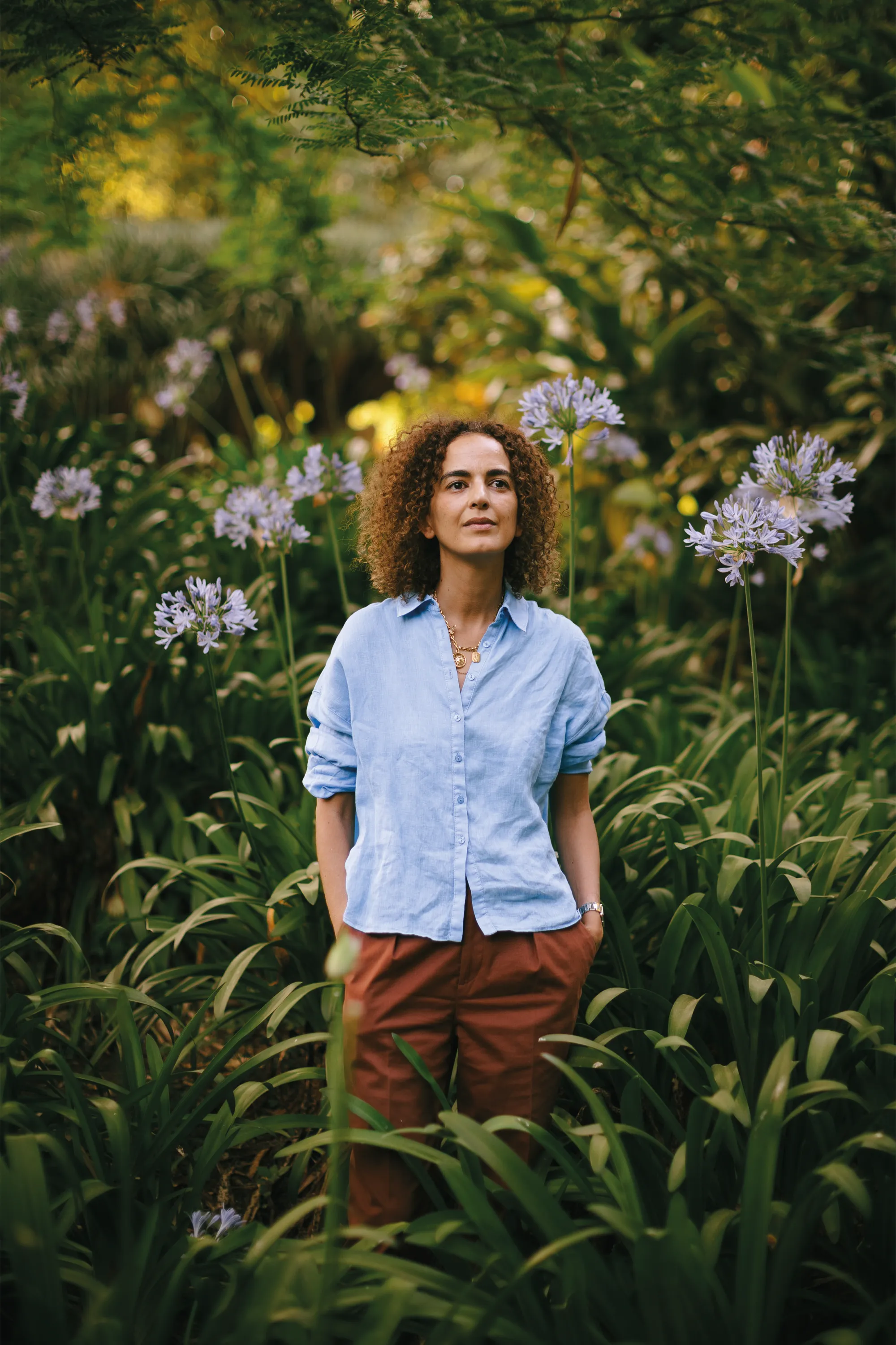 Leïla Slimani, portrait among agapanthus flowers in a garden