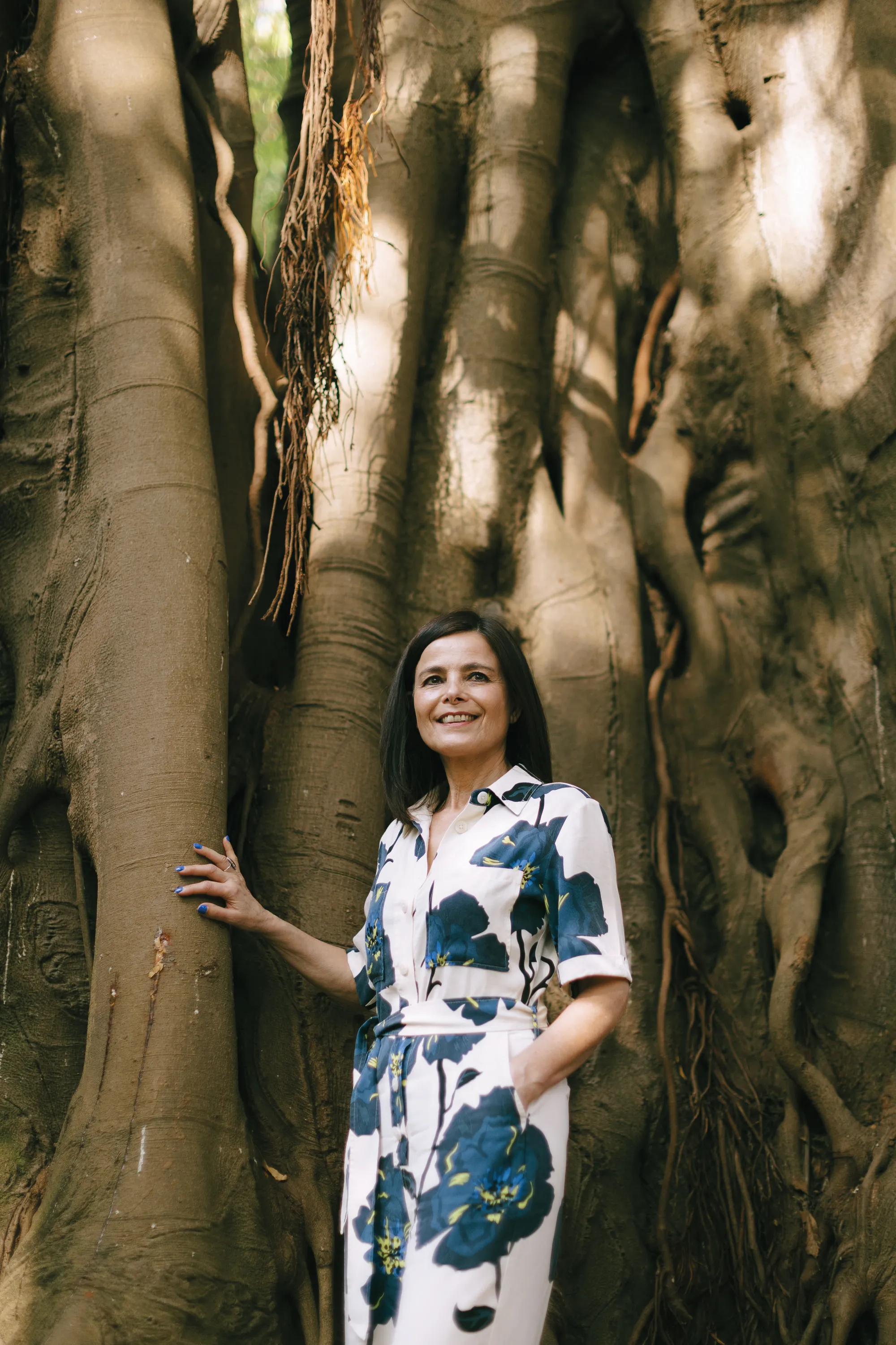 Maria Brandão, portrait in floral dress by a tree